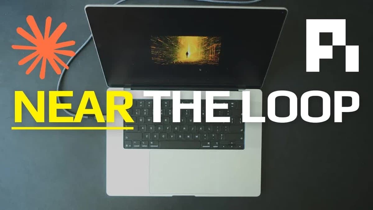 Bærbar datamaskin sett ovenfra på et mørkt bord, med et lysende bilde av en gang på skjermen og teksten «NEAR THE LOOP» over tastaturet.