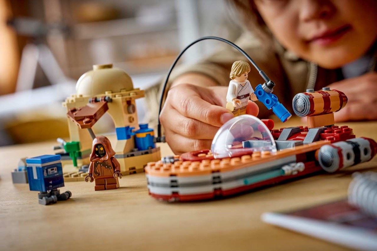 A child playing with 75420 Luke's Landspeeder on Tatooine with a Jawa and Gonk Droid